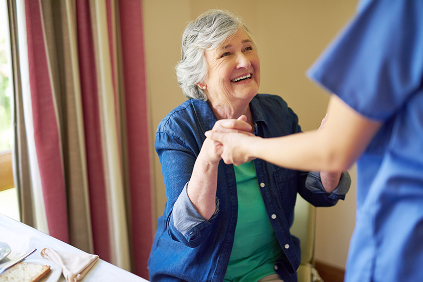 Giving her a helping hand. a resident and a nurse at a retirement home 