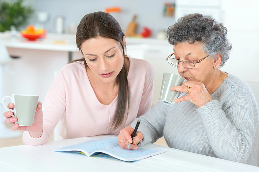 Senior woman and her daughter at the kitchen table